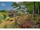 View of the brown two-story house with a deck in the backyard, with a hillside and surrounding trees at 1919 Madeira Cir, Waxhaw, NC 28173