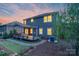 Backyard with a spacious deck, covered patio, manicured lawn, and mature trees at twilight at 1919 Madeira Cir, Waxhaw, NC 28173