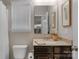 Bathroom featuring a wooden vanity with granite countertop and a decorative mirror at 1919 Madeira Cir, Waxhaw, NC 28173