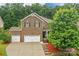 Two-story brick home boasting a three-car garage and well-maintained landscaping provides great curb appeal at 1919 Madeira Cir, Waxhaw, NC 28173