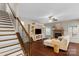 Inviting living room with dark wood floors, fireplace, and entertainment center by the stairs at 1919 Madeira Cir, Waxhaw, NC 28173