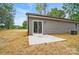 A spacious backyard featuring gray siding, a sliding glass door, and a small concrete patio at 195 Linda St, Salisbury, NC 28146
