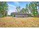A spacious backyard featuring gray siding, a sliding glass door, and a small concrete patio at 195 Linda St, Salisbury, NC 28146