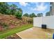 Private backyard with patio, retaining wall with new greenery, and white privacy fence at 2018 Crooked Oak Ln, York, SC 29745