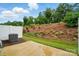 Private backyard patio with a retaining wall landscaped with small shrubs and new greenery at 2018 Crooked Oak Ln, York, SC 29745