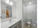 Well-lit bathroom with a large mirror, neutral-colored vanity, and shower with colorful curtain at 2018 Crooked Oak Ln, York, SC 29745
