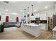 Open-concept kitchen with an island, sleek pendant lighting, and stainless-steel appliances at 2018 Crooked Oak Ln, York, SC 29745