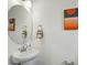 Stylish powder room with a pedestal sink, round mirror, and modern artwork at 2018 Crooked Oak Ln, York, SC 29745