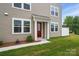 Two-story home with a red front door, white trim, and a green lawn at 2021 Vinyasa Ln # Sts-41, Charlotte, NC 28215