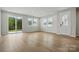 Open-concept living room area with wood floors, lots of windows, and sliding glass door to patio at 2021 Vinyasa Ln # Sts-41, Charlotte, NC 28215
