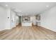 Open-concept living room with a view of the kitchen featuring wood floors and neutral paint at 2021 Vinyasa Ln # Sts-41, Charlotte, NC 28215