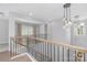 Second floor landing with natural wood railing and view of modern hanging light fixture at 2026 Thatcher Way, Fort Mill, SC 29715