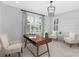 Bright home office featuring a wooden desk, chairs, and a window with white shutters and decorative curtains at 2026 Thatcher Way, Fort Mill, SC 29715