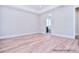 Light-filled bedroom featuring hardwood floors, neutral walls, and an en-suite bathroom with a tub at 20392 Queens St, Cornelius, NC 28031