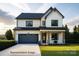 Two story home featuring a black roof, front-facing two car garage, and a well-manicured lawn at 20392 Queens St, Cornelius, NC 28031