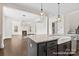 Kitchen island featuring a farmhouse sink and granite countertops at 20392 Queens St, Cornelius, NC 28031