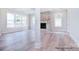 Spacious living room with a stone fireplace and large windows providing plenty of natural light at 20392 Queens St, Cornelius, NC 28031