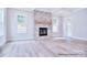 Spacious living room featuring a stone fireplace, large windows, and hardwood floors at 20392 Queens St, Cornelius, NC 28031