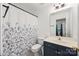 This bathroom features a floral shower curtain, white toilet, vanity, and decorative mirror at 220 Glenville Dr, Fort Mill, SC 29715