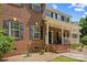 Traditional brick home with a welcoming front porch, black shutters, and mature landscaping at 220 Glenville Dr, Fort Mill, SC 29715