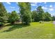 Beautiful home nestled among mature trees, boasting a lush front lawn and charming front porch at 220 Glenville Dr, Fort Mill, SC 29715