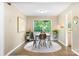 Bright dining room with a wood table set, neutral walls, and a view to the greenery outside at 2638 Park Rd # H, Charlotte, NC 28209