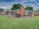 Expansive backyard featuring a brick patio, wooden deck, lush lawn, and meticulous landscaping at 269 Johnson Dairy Rd, Mooresville, NC 28115
