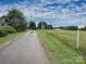 Scenic driveway leading to the property with a farm and tower on a verdant lawn under a blue sky at 269 Johnson Dairy Rd, Mooresville, NC 28115