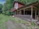 Exterior view of a vintage house with a rustic porch and a wooden facade nestled in a wooded area at 269 Johnson Dairy Rd, Mooresville, NC 28115