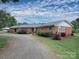 Attractive brick home featuring a landscaped yard, gravel driveway, and a covered carport at 269 Johnson Dairy Rd, Mooresville, NC 28115