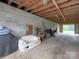 View of the garage featuring a concrete floor, cinder block walls, and wood ceiling with exposed rafters and stored items at 269 Johnson Dairy Rd, Mooresville, NC 28115