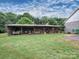 Exterior view of a rustic storage shed with open sides and a variety of equipment and materials inside at 269 Johnson Dairy Rd, Mooresville, NC 28115
