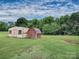 Exterior view of two storage sheds with a grass yard and wooded area in the background at 269 Johnson Dairy Rd, Mooresville, NC 28115