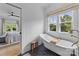 Bright bathroom featuring free-standing tub and outside view from the window at 304 Keswick Ave, Charlotte, NC 28206