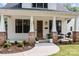 Inviting front porch with brick columns, decorative plants, and stylish seating arrangement at 304 Keswick Ave, Charlotte, NC 28206