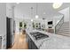 Open kitchen with island cooktop, marble countertops, stainless appliances, and hardwood floors at 304 Keswick Ave, Charlotte, NC 28206