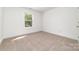 Bright bedroom featuring neutral carpet, a window, and crisp white walls at 312 Adams St, Salisbury, NC 28144