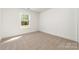 Bright bedroom featuring neutral carpet, a window, and crisp white walls at 312 Adams St, Salisbury, NC 28144