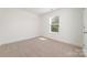 Bright bedroom featuring neutral carpet, a window, and crisp white walls at 312 Adams St, Salisbury, NC 28144