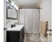 A bathroom features a vanity with a black faucet and a shower with patterned curtain at 327 Holly Dr, Mount Holly, NC 28120