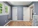 A cozy bedroom features a window, two doors, and wood-look flooring at 327 Holly Dr, Mount Holly, NC 28120