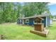 Blue house featuring landscaped yard, well, and covered picnic area at 327 Holly Dr, Mount Holly, NC 28120