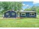 Charming blue home featuring a well-maintained yard and appealing landscaping at 327 Holly Dr, Mount Holly, NC 28120