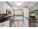The contemporary kitchen features stainless appliances, granite counters, and white cabinetry at 327 Holly Dr, Mount Holly, NC 28120