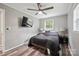 Bedroom featuring gray walls, ceiling fan, and mounted TV on wall at 327 Holly Dr, Mount Holly, NC 28120