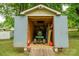 View of a shed with a riding lawnmower and shelves for storage, providing functional space at 327 Holly Dr, Mount Holly, NC 28120