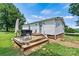 Cozy home with a wooden deck, stone pathway, and vibrant green lawn at 338 Hickory Grove Rd, Harmony, NC 28634