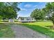 Charming single-story home with green shutters, a lush lawn, storage shed, and gravel driveway at 338 Hickory Grove Rd, Harmony, NC 28634