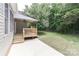 A lovely back porch with wood railing overlooks a beautifully manicured lawn and mature trees at 3709 Creek Ridge Dr, Denver, NC 28037