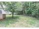Expansive backyard with lush green grass, mature shade trees, and rustic wooden fence provides privacy and natural beauty at 3709 Creek Ridge Dr, Denver, NC 28037